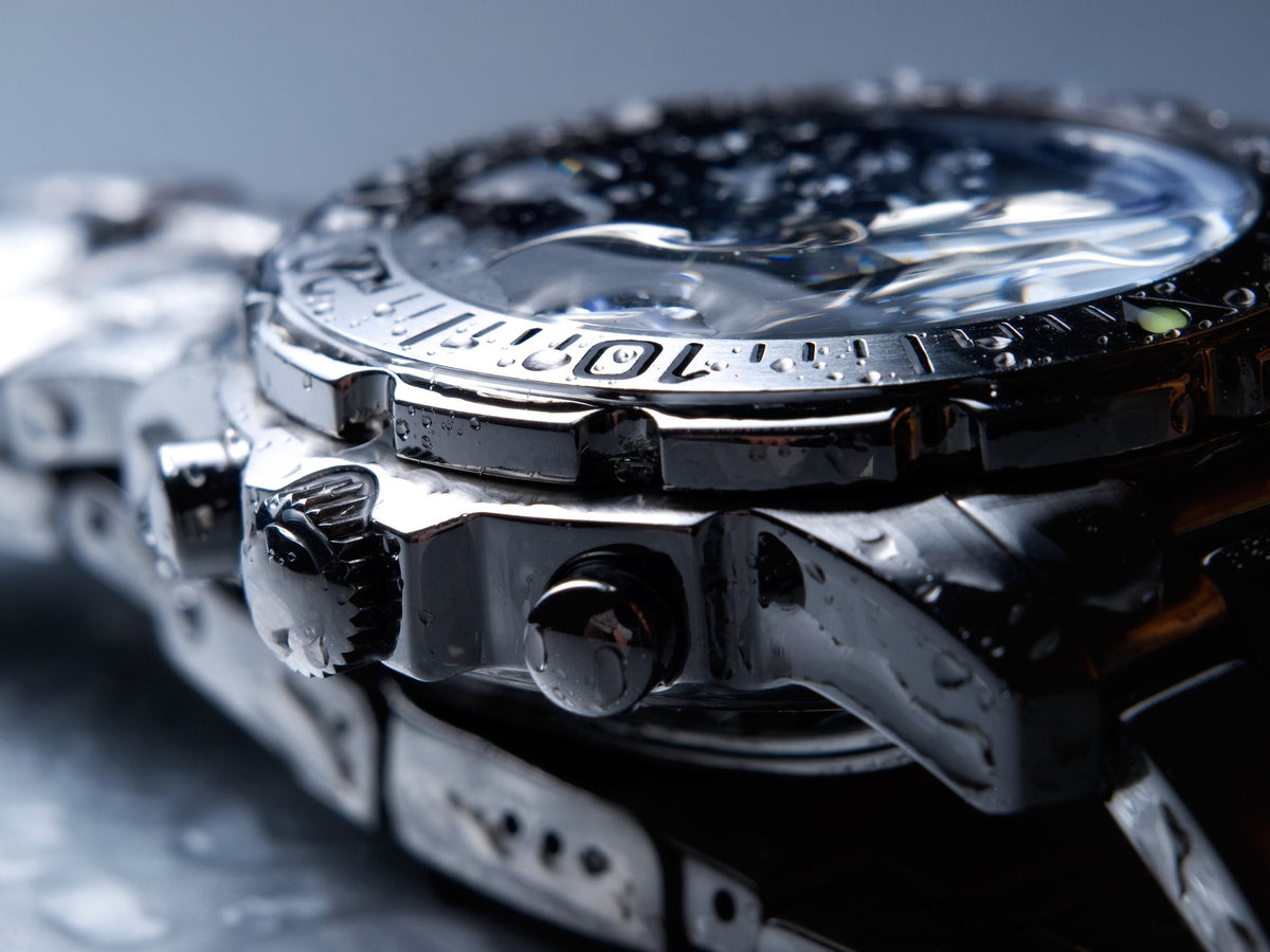 A wristwatch covered in water droplets, close up