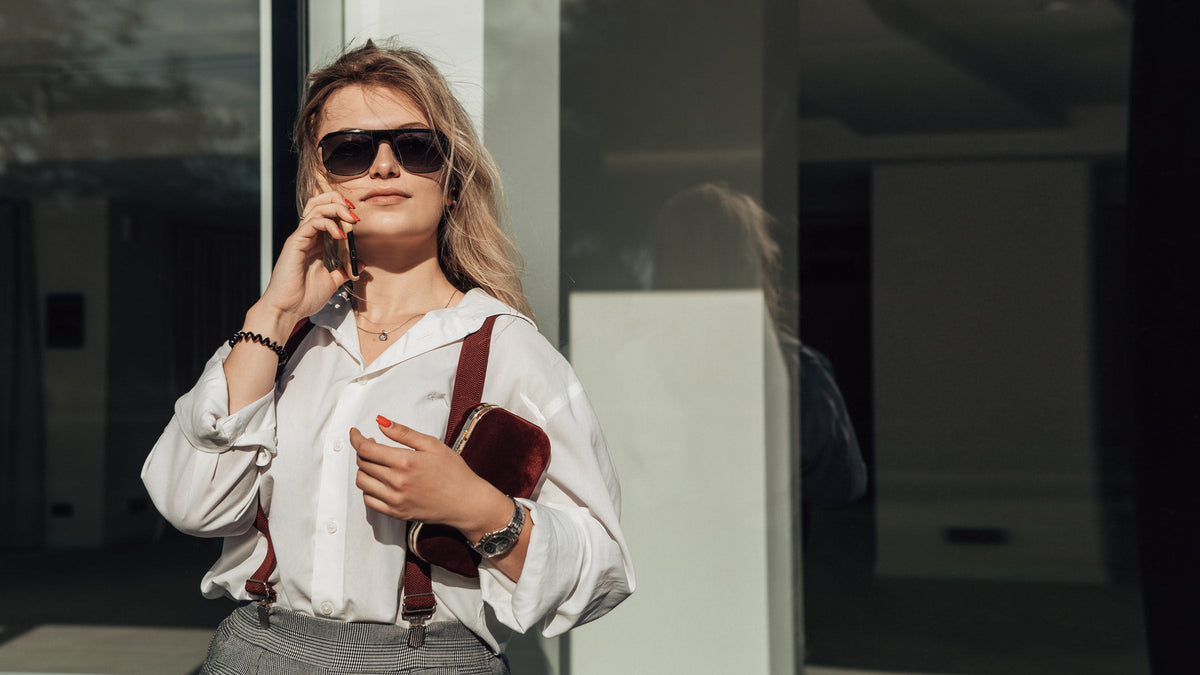 A businesswoman by a city window wearing a wristwatch