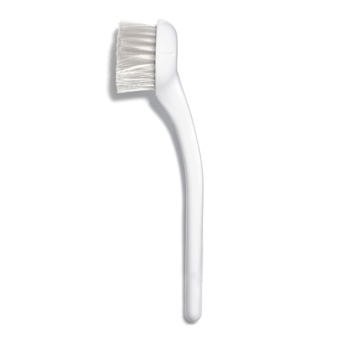 Compact soft-bristle facial and neck cleansing brush with ergonomic handle