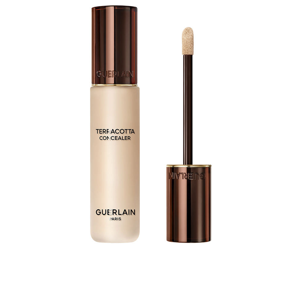 Guerlain Beige and dark brown liquid concealer in transparent cylindrical bottle with metallic cap and wand.