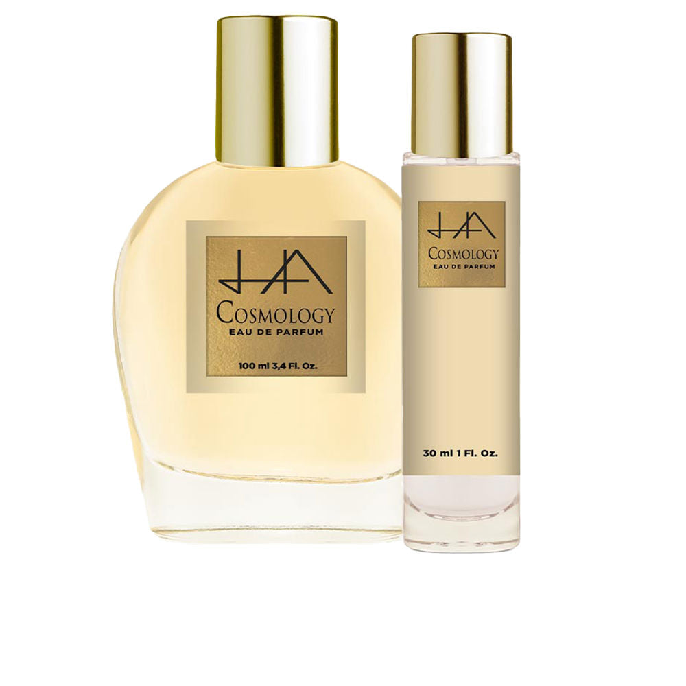 Hannibal Laguna Two rounded transparent glass Eau de Parfum bottles with gold caps and rectangular labels, minimalist beige tones.