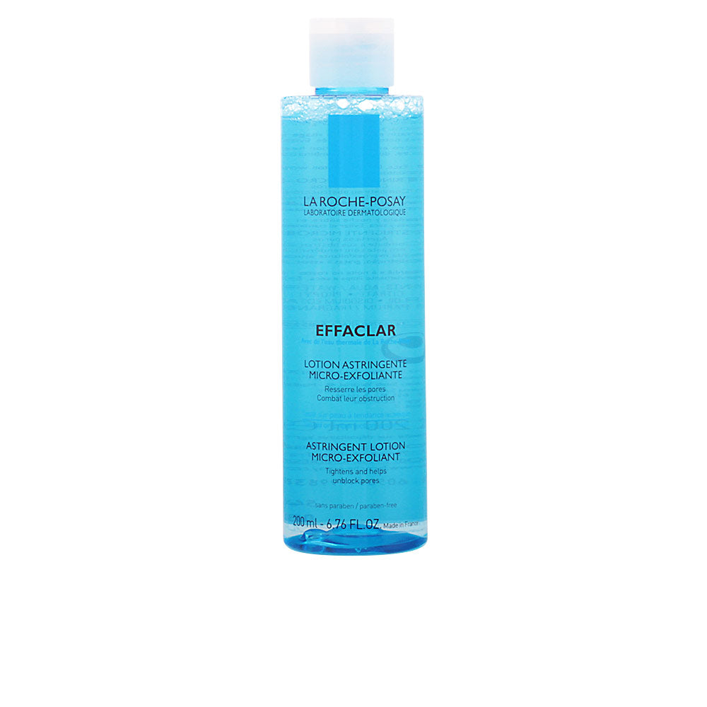 Transparent rectangular blue plastic bottle with white cap, black text and visible liquid inside, la Roche Posay