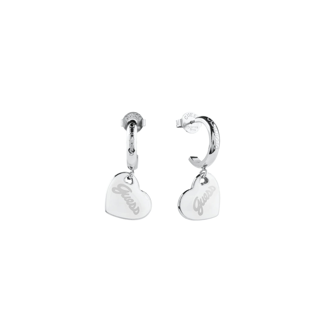 Silver hoop earrings each with a dangling engraved heart charm, polished metal finish, shown on white background