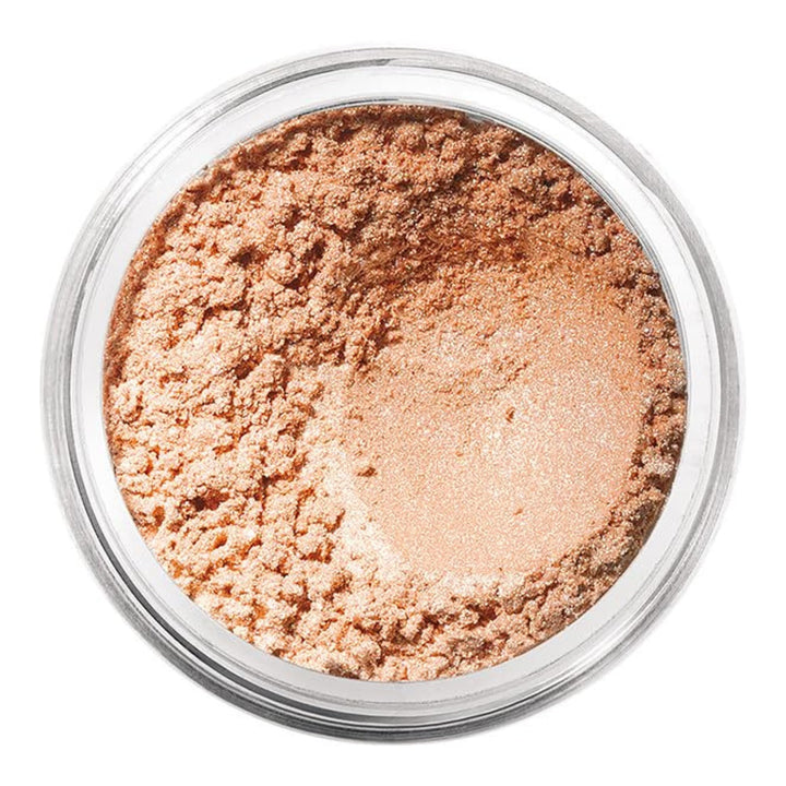 Small jar of loose mineral eyeshadow in warm nude shade, fine powder texture