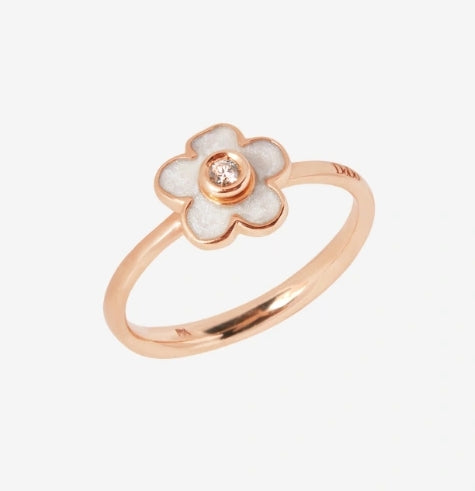 Rose gold floral ring with white enamel petals and a small diamond accent on polished band