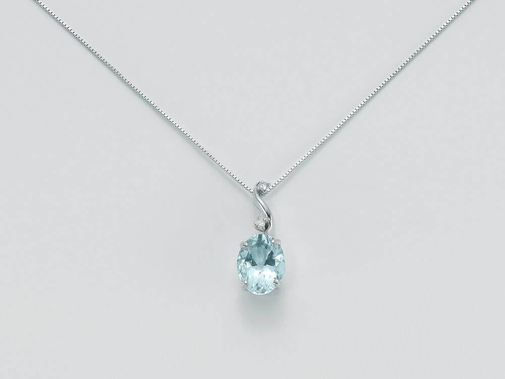 Silver pendant necklace featuring oval aquamarine center, two small diamonds above, on delicate silver chain
